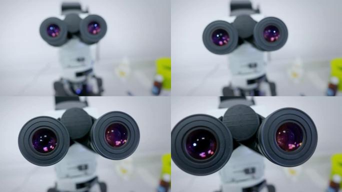 女科学家寻找显微镜目镜。通过显微镜观察的女科学家肖像