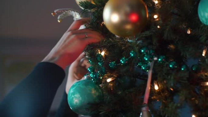一名男子在一家餐馆的公司聚会上装饰圣诞树。