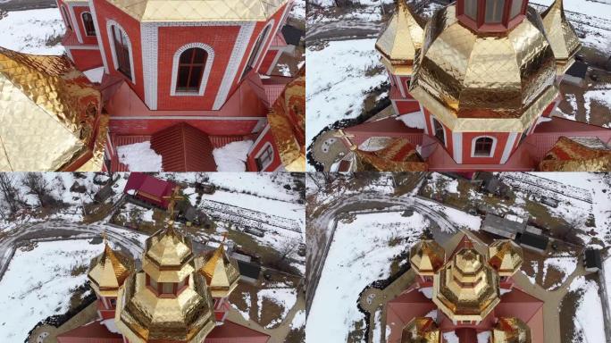 冬季喀尔巴阡山村带有金色圆顶的乌克兰教堂的空中俯视图