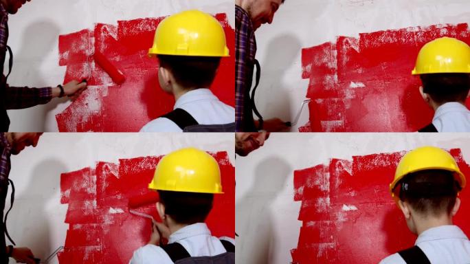 幸福的家庭修理公寓-小男孩和他的父亲用红色粉刷墙壁