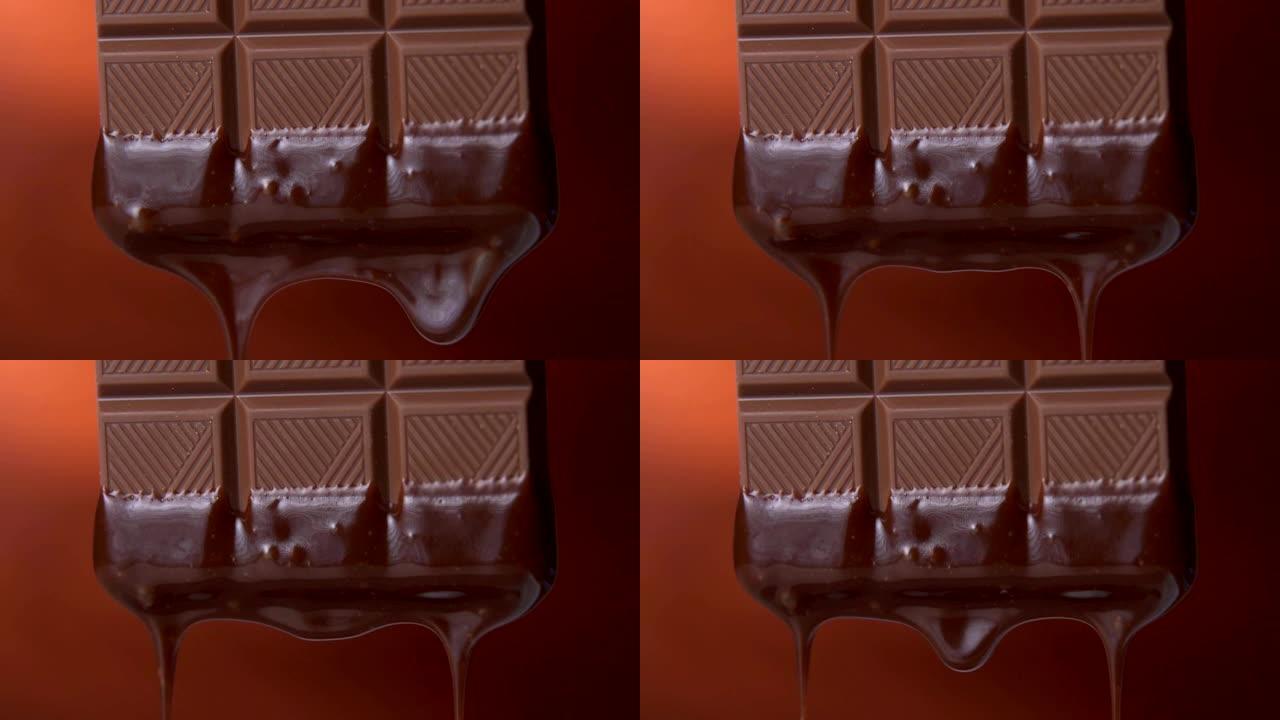 棕色背景上滴着融化的黑巧克力的巧克力棒