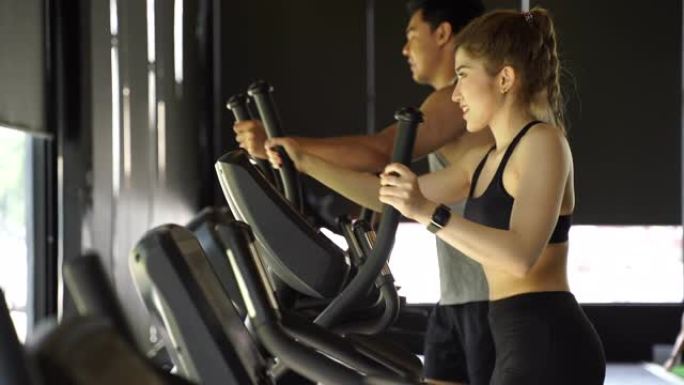 迷人的亚洲健身女性在健身房使用椭圆形训练器，有复制空间。健康和减肥的生活方式