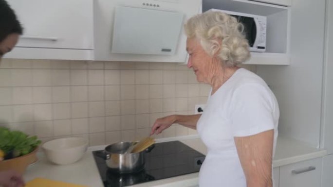 微笑的女人帮助祖母做饭。