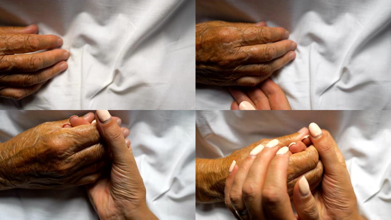 女人握住并轻轻地抚摸母亲的手，表现出关怀或爱心。女儿安慰躺在床上的年迈妈妈皱巴巴的手掌。支持她的老父
