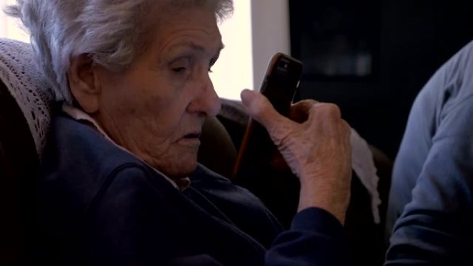 一位老人向90多岁的老妇人展示智能手机