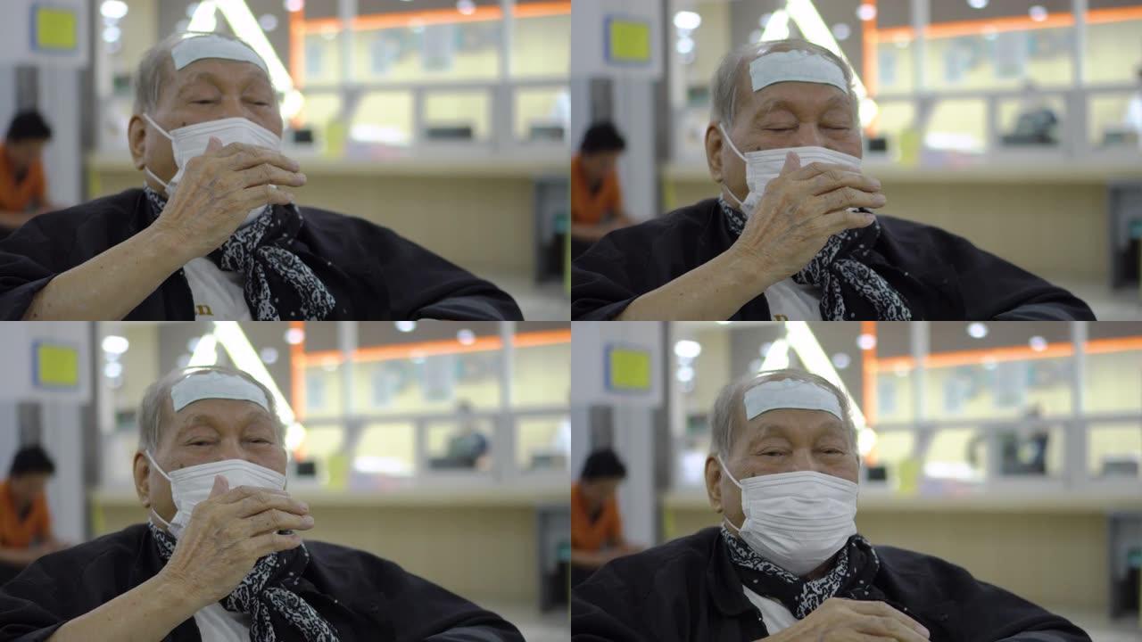 资深亚裔男子戴口罩在医院等候时咳嗽