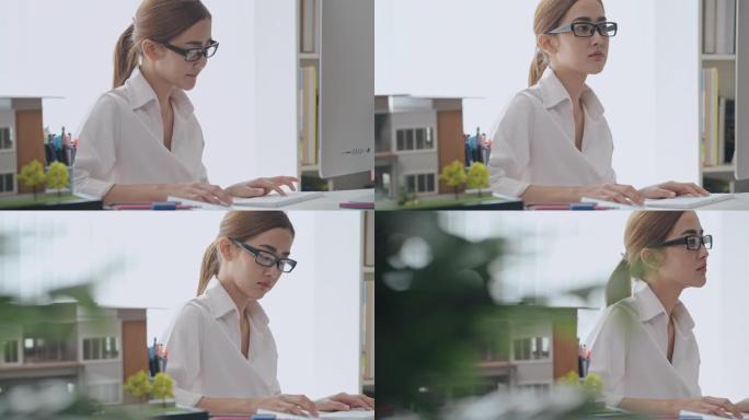 多莉拍摄的亚洲女性在电脑上做建筑师设计。努力思考。