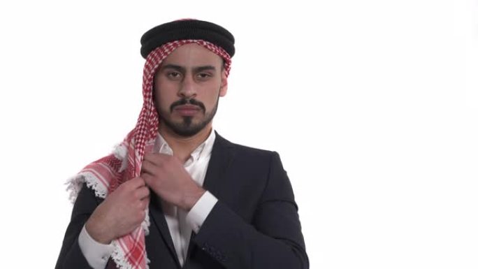 阿拉伯男子佩戴和贴合传统男性东方头饰kufiya的特写演示视频。孤立，在白色背景上
