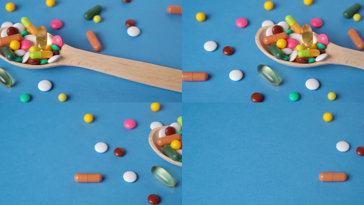 木勺充满药丸，片剂，维生素，药物，欧米茄3鱼油，凝胶胶囊，药物和食品补充剂的保健。蓝色背景。