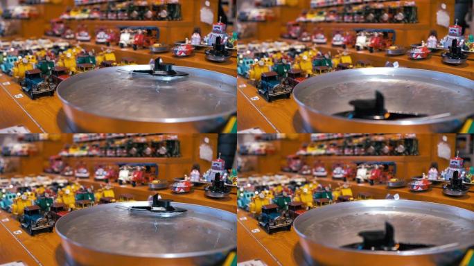 机动玩具船在扫水和背景中的其他木制玩具中盘旋