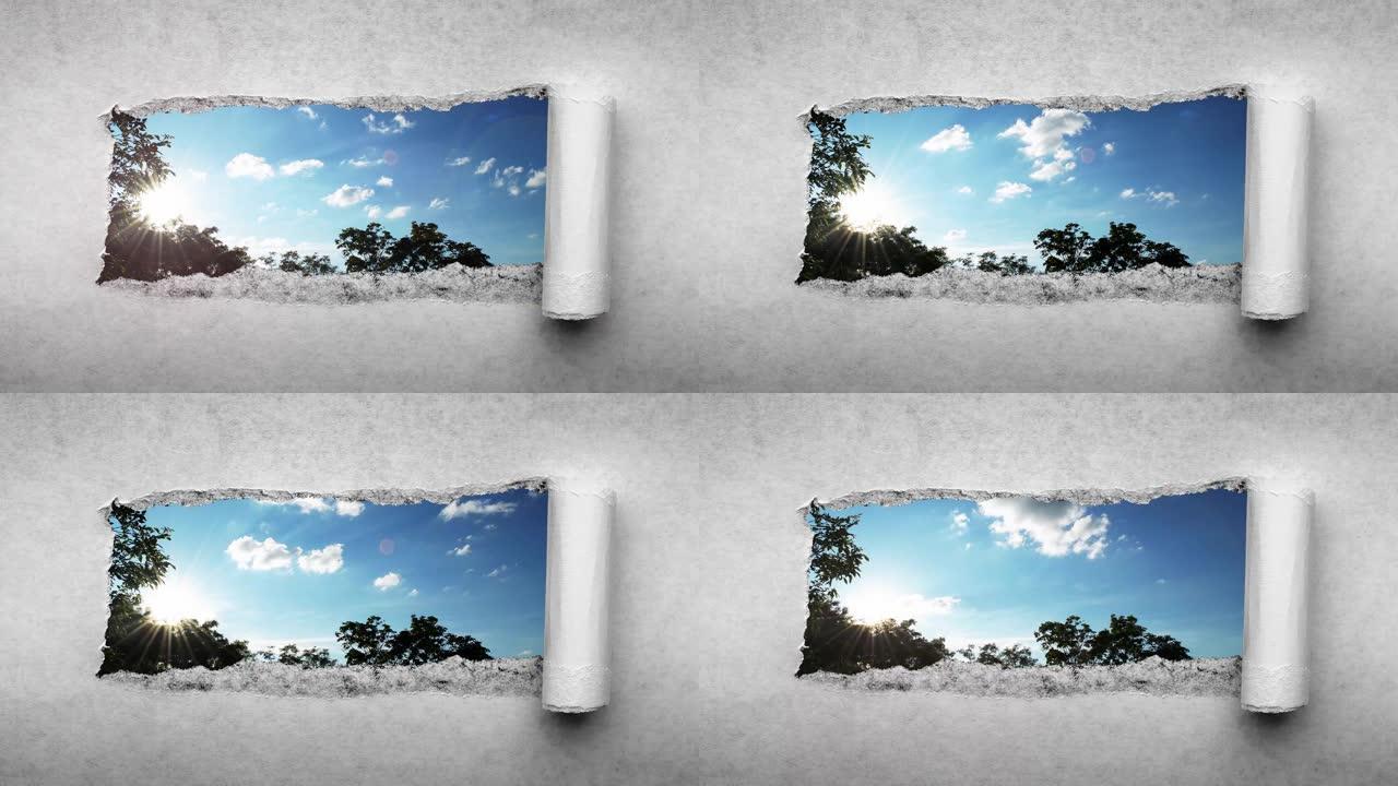创意4k时间圈视频，在日落时分在蓝天中快速移动的云彩，这些云彩可以通过旧复古垃圾老式纸张边缘撕裂的孔
