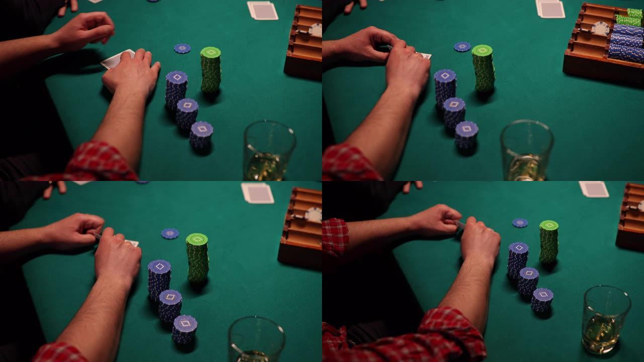 男子在德州扑克比赛中看着自己的牌