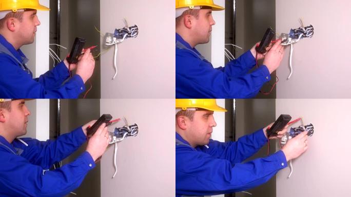 男电工用专用设备检查插座。戴头盔的人