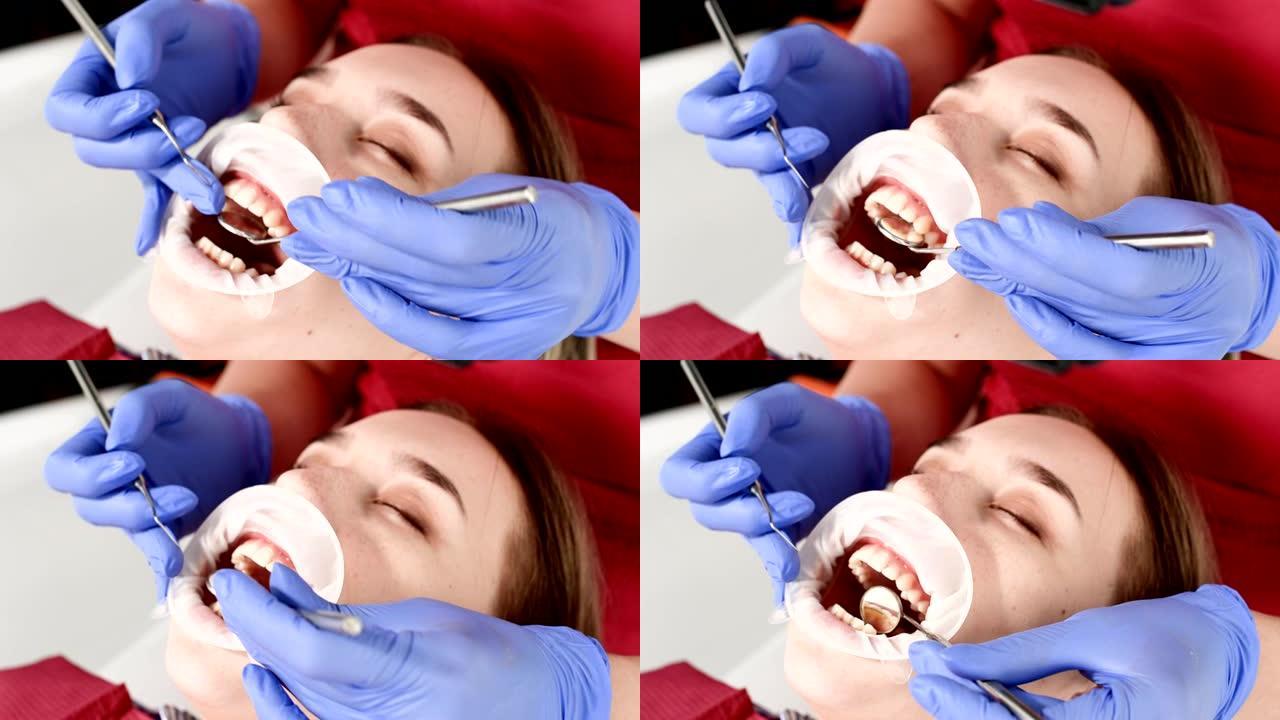 牙科检查员张开嘴，用餐巾纸和闭着眼睛检查女孩的脸部特写。带有检查工具的牙医手