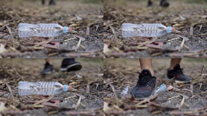 男人的腿踩着塑料瓶捡起来，停止塑料，环保概念
