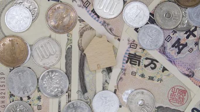 旋转拍摄顶视图木制家庭图标在日本货币日元货币钞票。