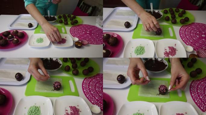 一个女人把巧克力球洒在海绵蛋糕上。做一个土豆蛋糕。盘子旁边是蛋糕坯料，液体巧克力和彩色洒。