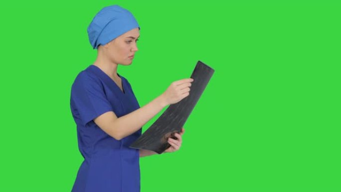 严肃的女医生在绿色屏幕上看脑部MRI扫描，色度键