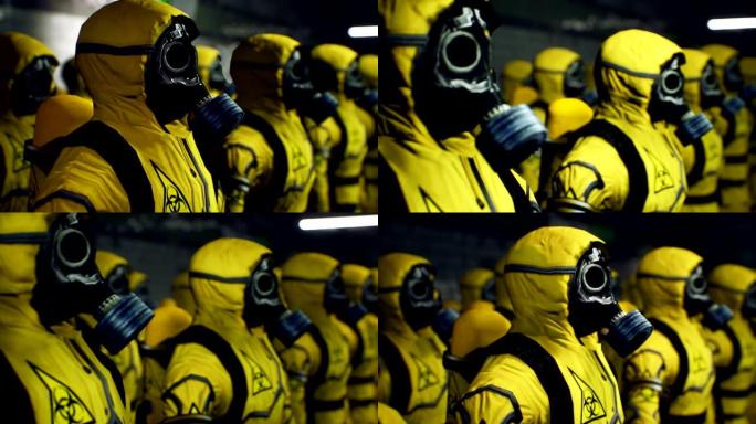 穿着黄色防护服的医护人员在工作日开始前排队。穿着细菌防护服和防毒面具的人。