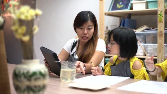 美术班老师在美术工作室教亚洲中国儿童绘画