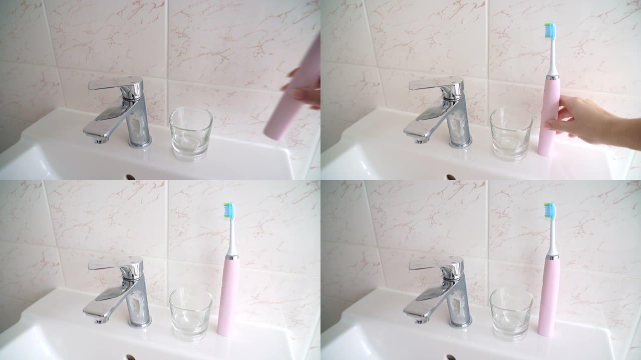 家里浴室里的粉色电动牙刷和玻璃。与口腔护理产品和牙科护理工具组成。