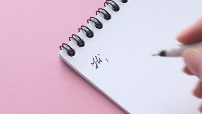 女性手写字母开头单词亲爱的先生在粉红色背景的白色便条纸上，特写