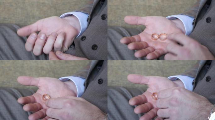 男人的手掌上是结婚戒指。这个人挤压戒指。