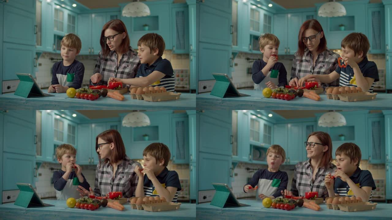 一家人一起烹饪站在蓝色厨房的平板电脑上看在线食谱。两个孩子在家帮妈妈做饭。孩子们吃甜红辣椒。