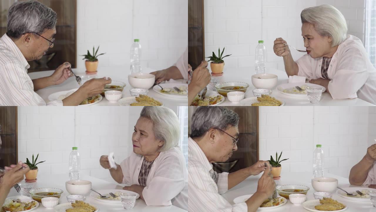 亚洲老年夫妇在家一起吃泰国菜带着幸福