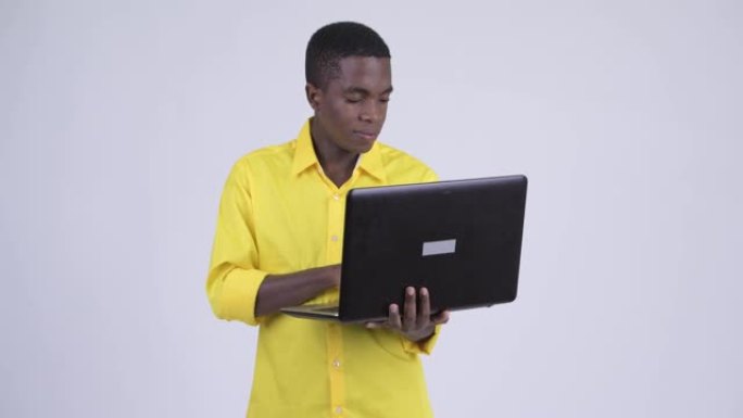 快乐年轻英俊的非洲商人使用笔记本电脑