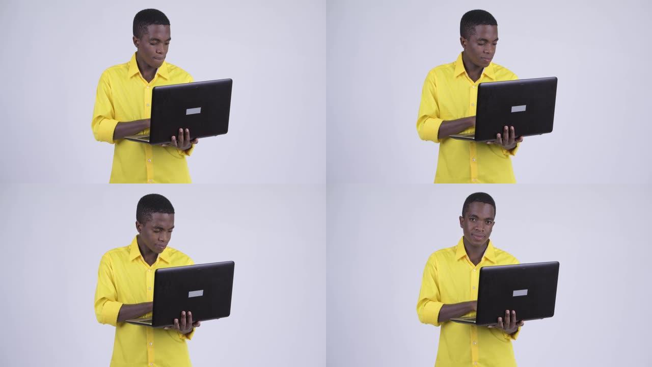 快乐年轻英俊的非洲商人使用笔记本电脑