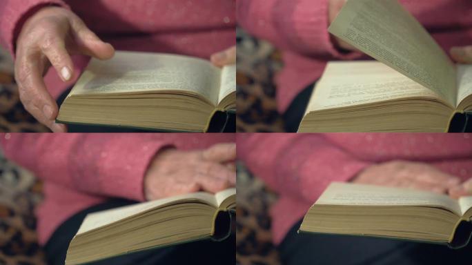 老妇人的手翻阅老式书籍的特写
