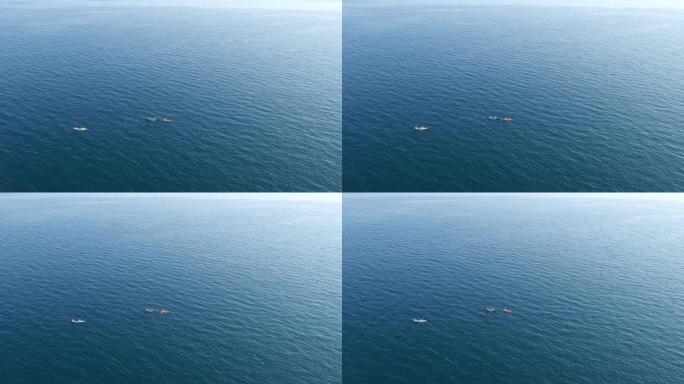 三艘皮划艇在公海游泳，岸边看不见。