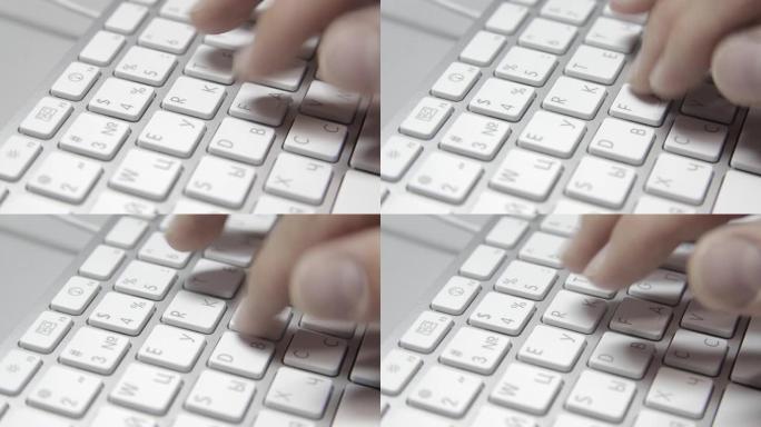 手在macbook键盘上打字。特写