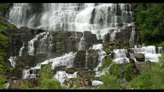 挪威霍达兰沃斯。春天的瀑布。年轻的高加索女性女士旅游旅行者徒步游览挪威最高的瀑布。著名的地标和热门目