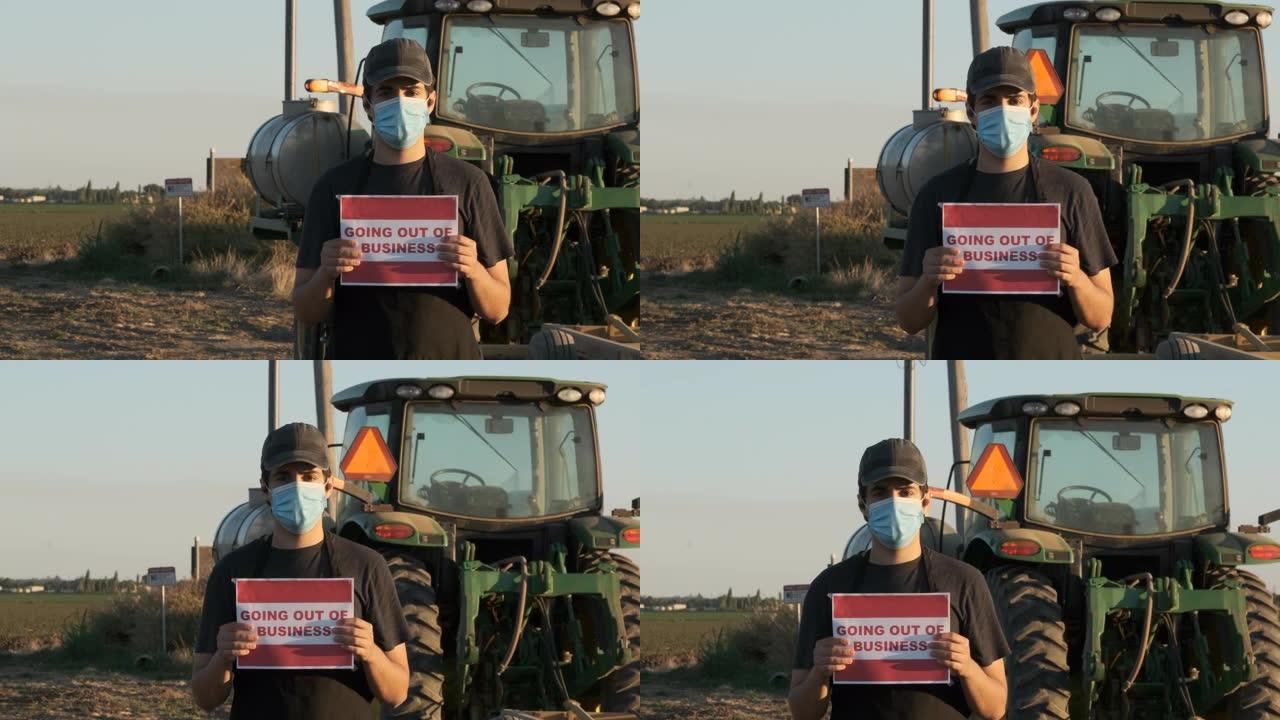 因新型冠状病毒肺炎传染而戴防护口罩的农民工手持 “倒闭” 标志