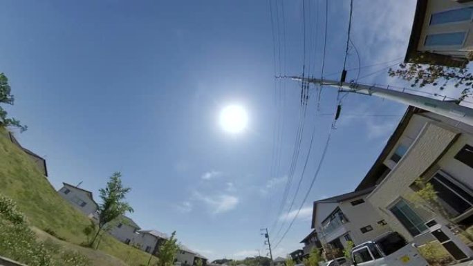 在住宅街道/电力线/太阳行驶