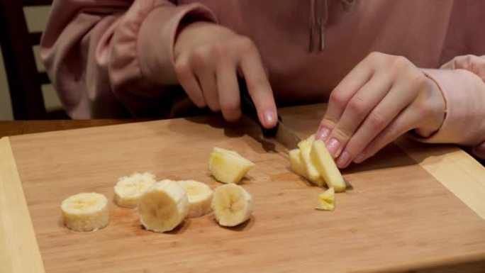 女孩在木板上切水果的裁剪镜头