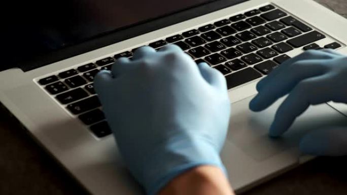 年轻的印度商人戴着医用口罩手套，坐在家庭办公室的笔记本电脑上工作。在冠状病毒covid 19检疫概念