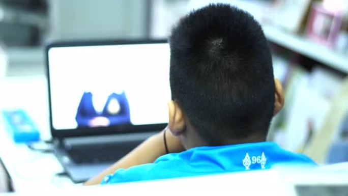 一个亚洲男孩在家在线学习。在全球流行病2020新型冠状病毒肺炎疫情的关键爆发期间