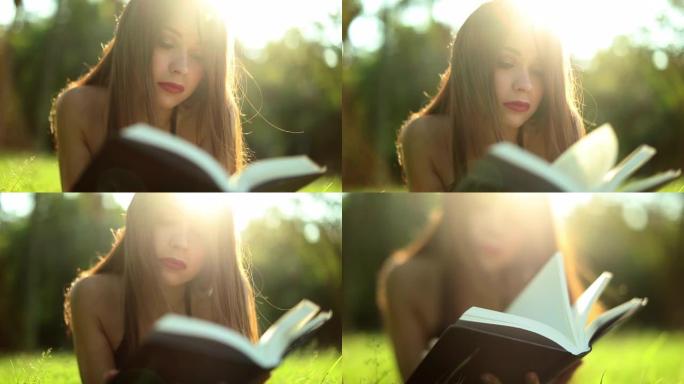 年轻女子在外面看书躺在草地上翻页。漂亮女孩读故事小说