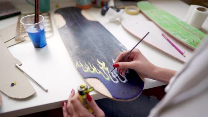 妇女在滑板板上绘画的特写镜头。