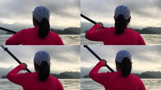 亚洲妇女早晨在热带大湖皮划艇。放松运动
