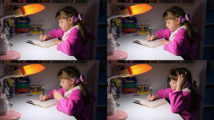 一个女孩在傍晚在台灯的灯光下做作业