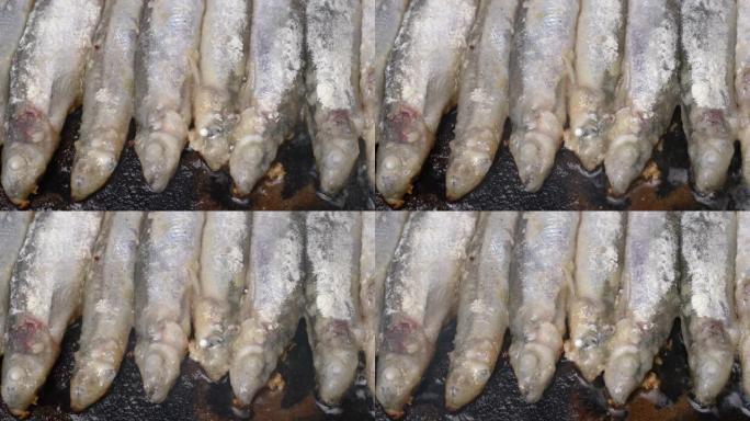 在铁锅中烹饪炸毛鳞鱼的特写视图。美味的日本食物 -- 烤卡普林鱼