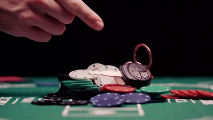 赌徒的特写镜头把他的车停在扑克桌中间的一堆筹码上