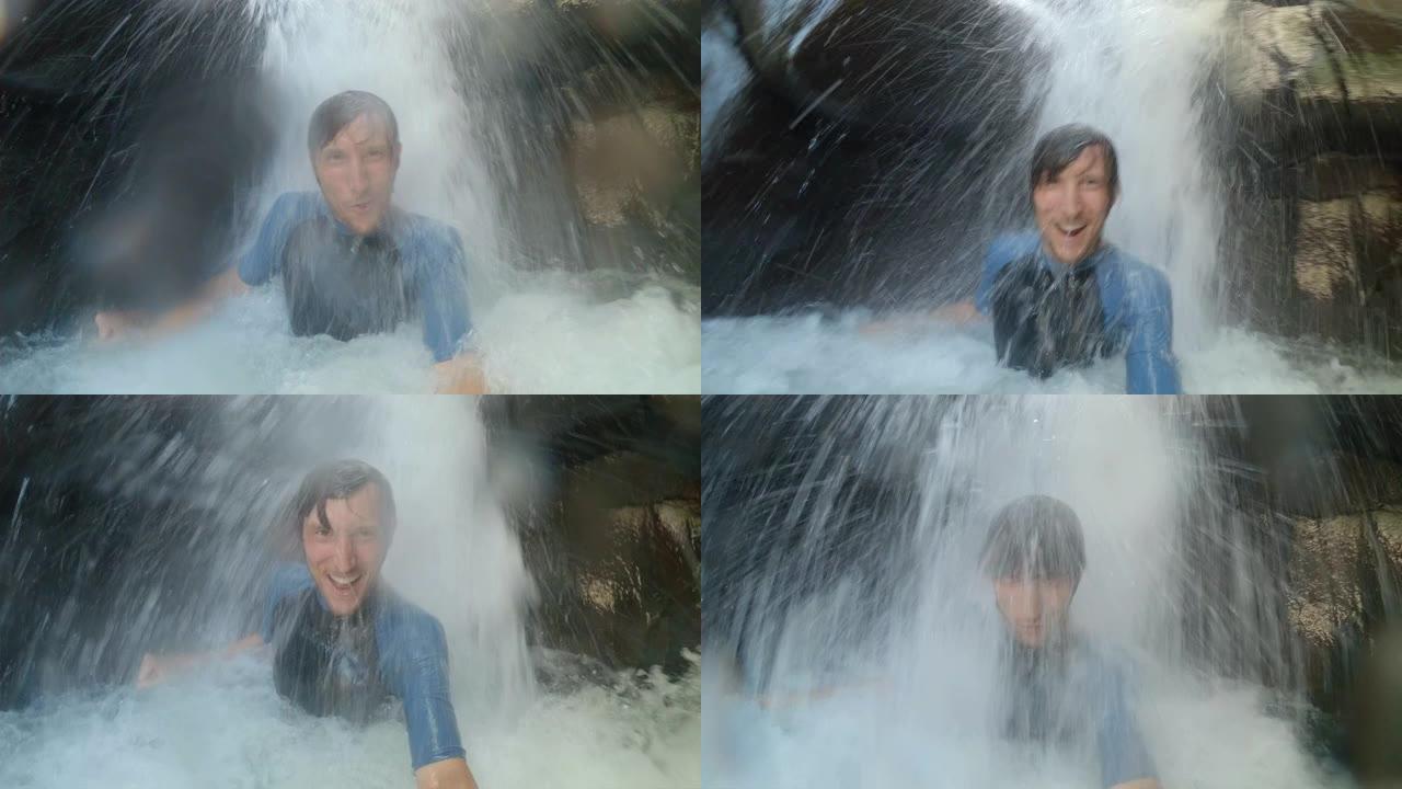 一个年轻人在热带河里用瀑布记录自己的慢动作镜头。夏季概念