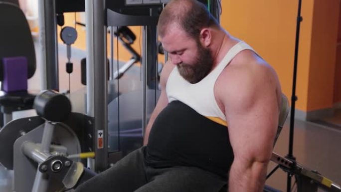 非常大的大胡子健美运动员在健身房训练腿