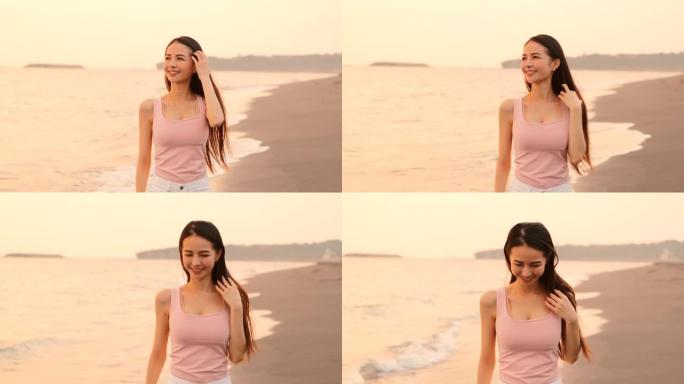 快乐的亚洲年轻女子在日落时在沙滩上散步