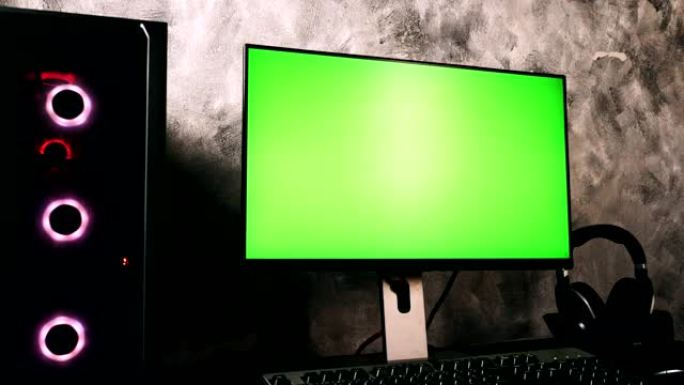 黑色电脑，带绿屏显示器在家里黑暗的房间里的桌子上
